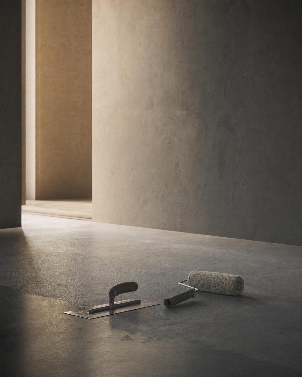 A hand checking a bare rendered wall before microcement goes on